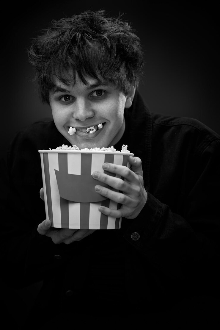 Portrait of young woman using mobile phone against black background